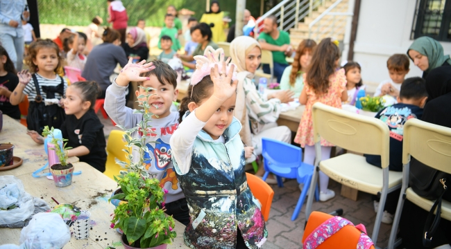 Aileler ve çocuklar, birlikte saksı boyayıp çiçek ekti